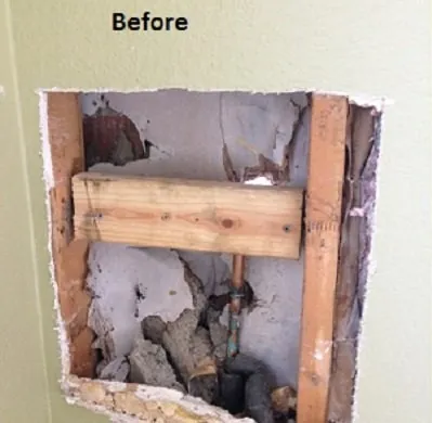 Before: a damaged section of wall opened to the studs