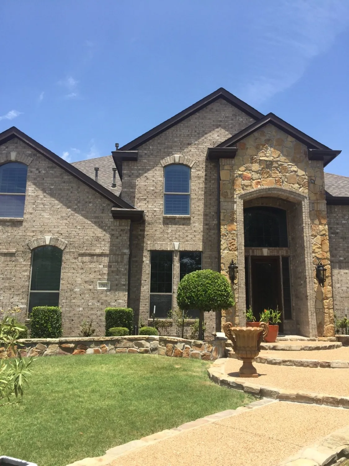 Brick and stone home with dark painted trim