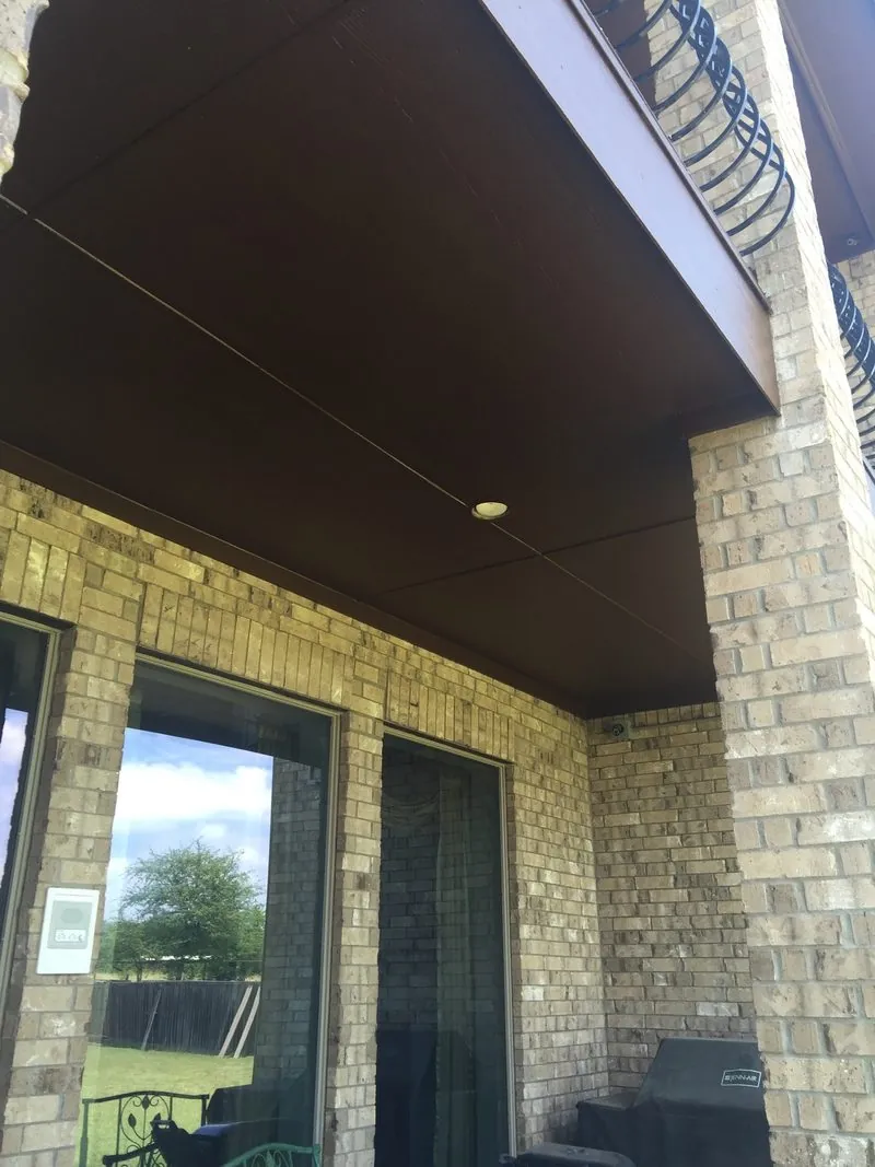 Covered patio with a dark brown painted ceiling
