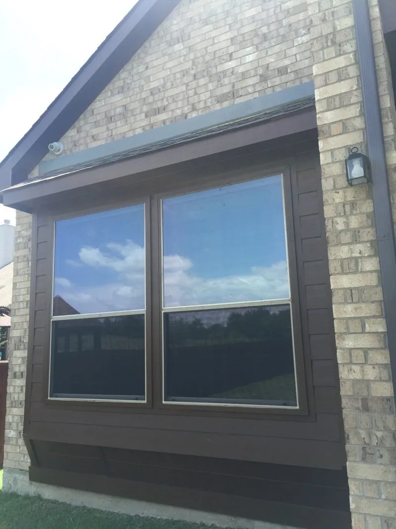 Window trim painted deep brown on a brick home